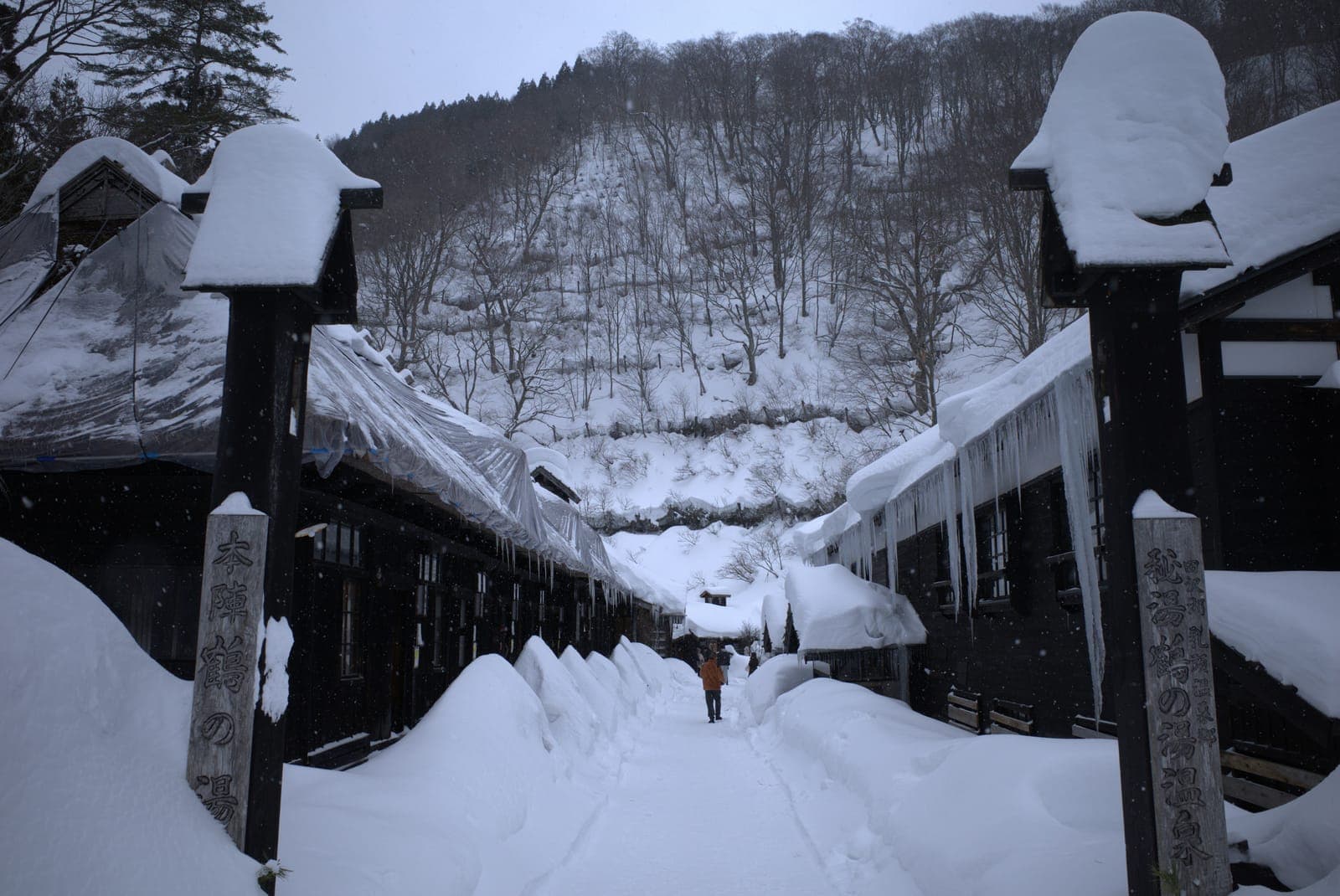 雪に埋もれた冬の秋田の温泉街の通り