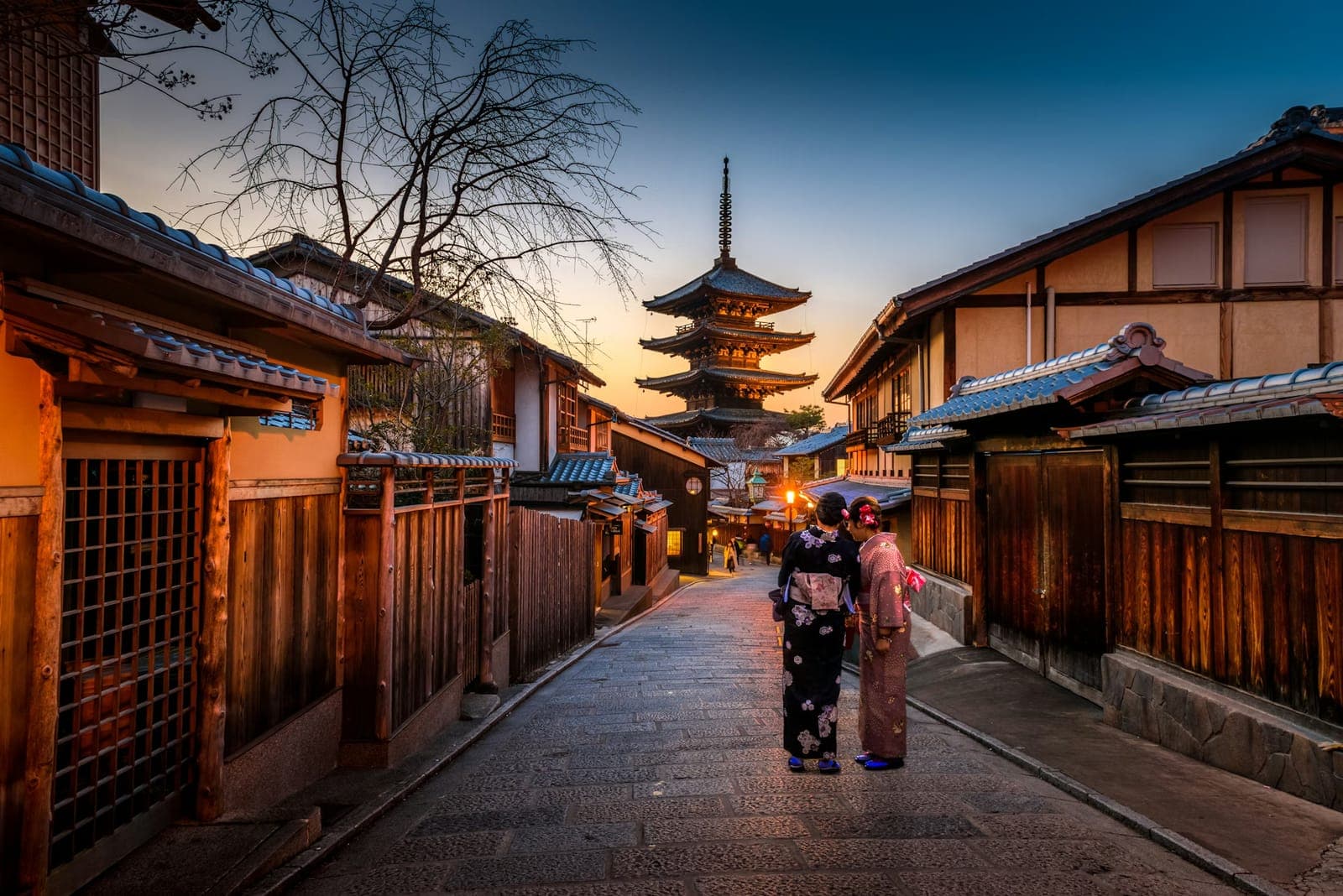 People walking through a Kyoto street at sundown